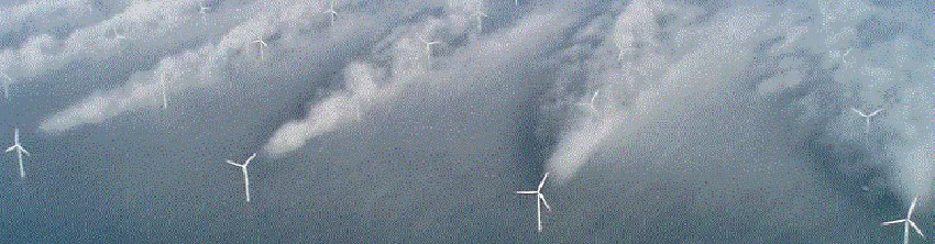 Vue aérienne d'un parc éolien offshore, sillages des éoliennes rendus visibles par le brouillard