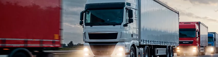 Camions poids lourds circulant sur une autoroute au crépuscule