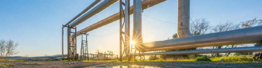 Canalisations industrielles surélevées au soleil couchant