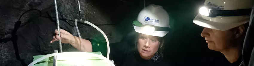 Deux chercheuses d'IFPEN en casque à lampe frontale installant un équipement de mesure dans une galerie souterraine