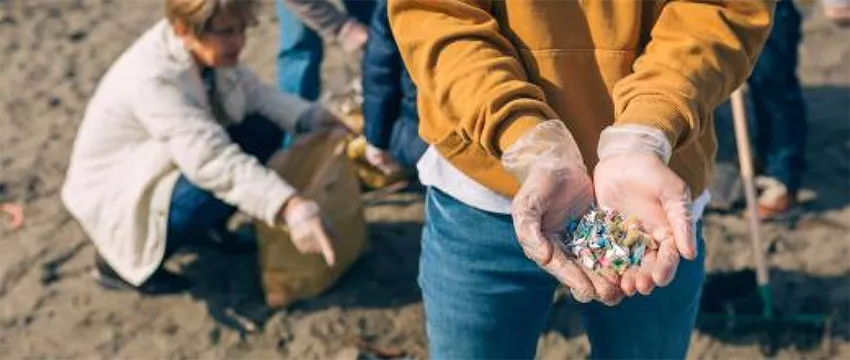 déchets plastiques sur une plage, collectés manuellement par des bénévoles