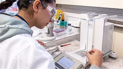 Collaboratrice d'IFPEN, portant des lunettes de sécurité, et travaillant dans un laboratoire