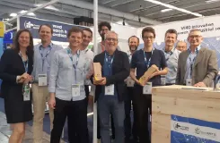 Équipe posant sur un stand de salon professionnel