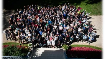 Vue en plongée d'un grand groupe de personnes posant ensemble dans un jardin