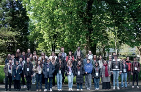 Groupe de doctorants posant en extérieur devant des arbres