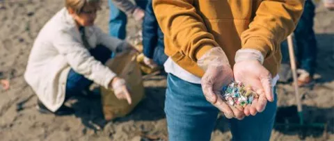 déchets plastiques sur une plage, collectés manuellement par des bénévoles